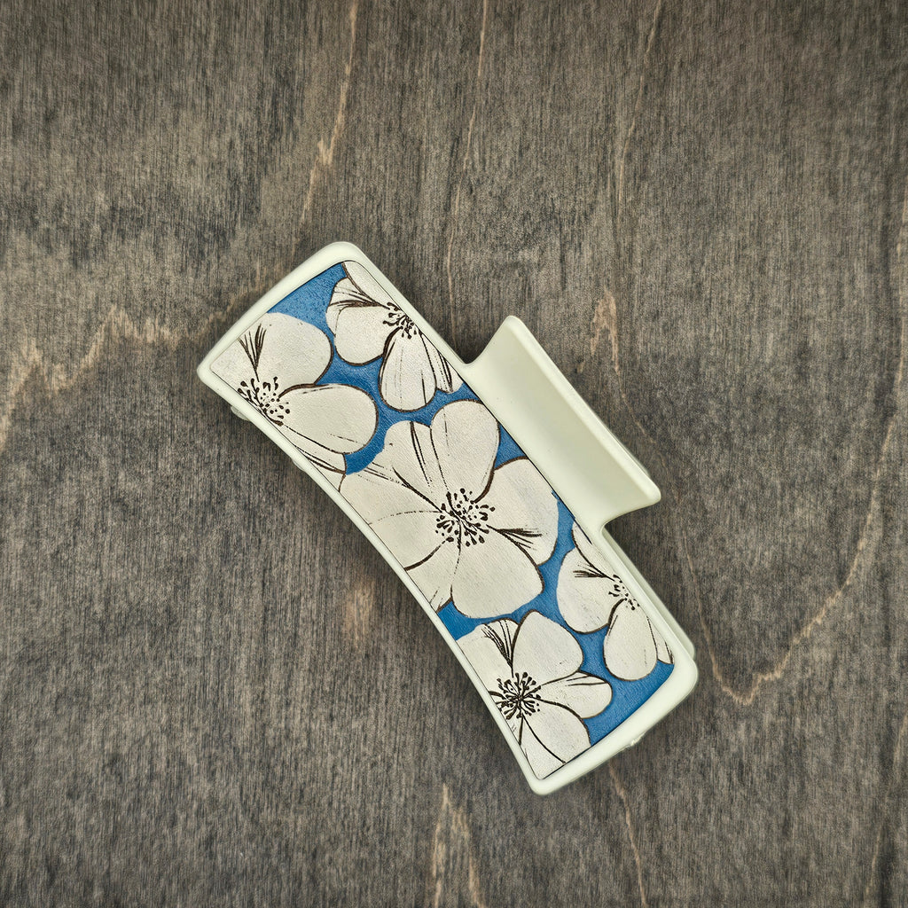 Hand-painted wood hair claw clip featuring large white hibiscus blooms on a blue-painted wood background