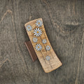 Large hand-painted wood hair claw clip featuring scattered white daisy flowers with yellow centers on a natural wood background