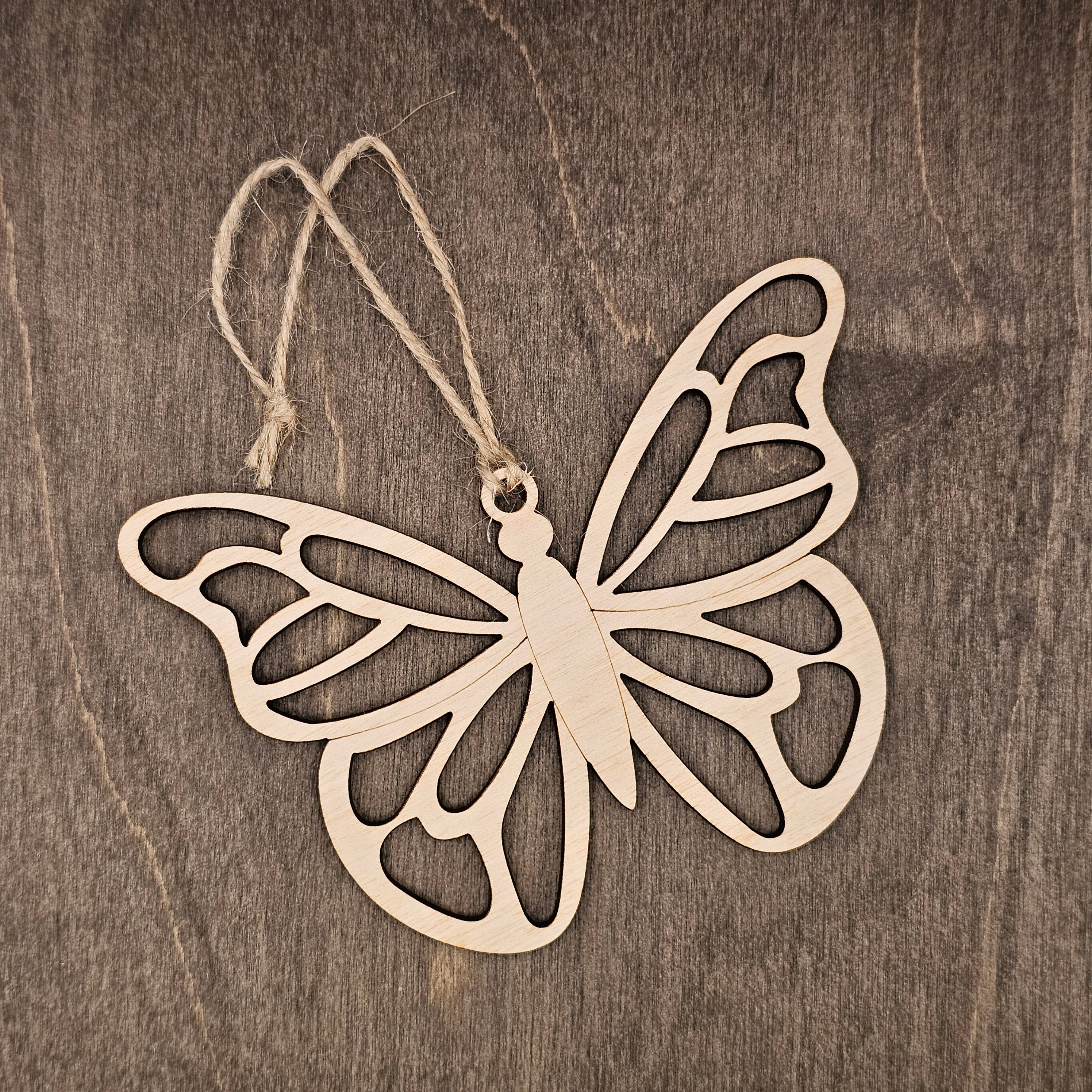 Laser cut wood butterfly ornament with intricate layered wing cutwork design, hung with natural jute cord