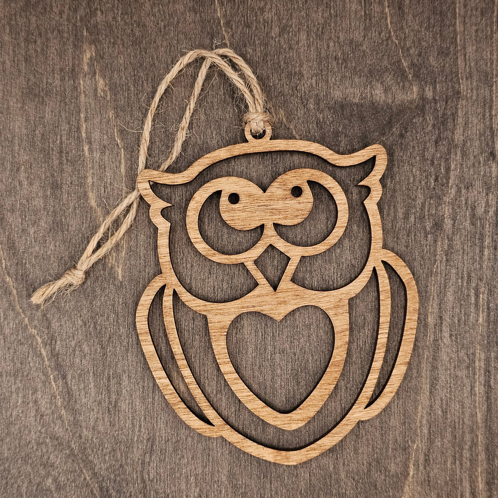 Laser cut owl wood ornament with open heart silhouette design and expressive face, hung with natural jute cord