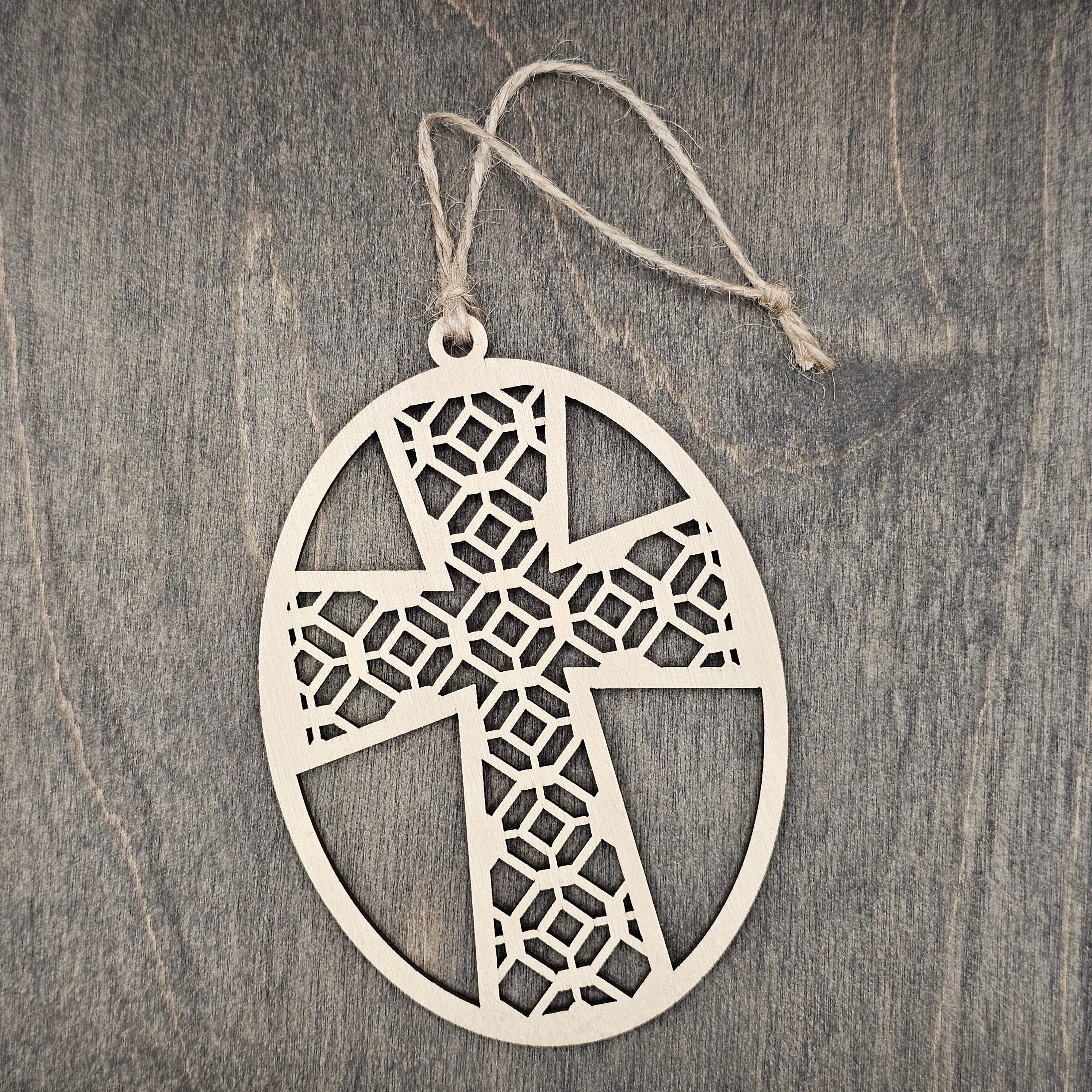 Laser cut Faith Over Fear cross wood ornament with intricate geometric lattice pattern inside an oval wood frame, hung with natural jute cord