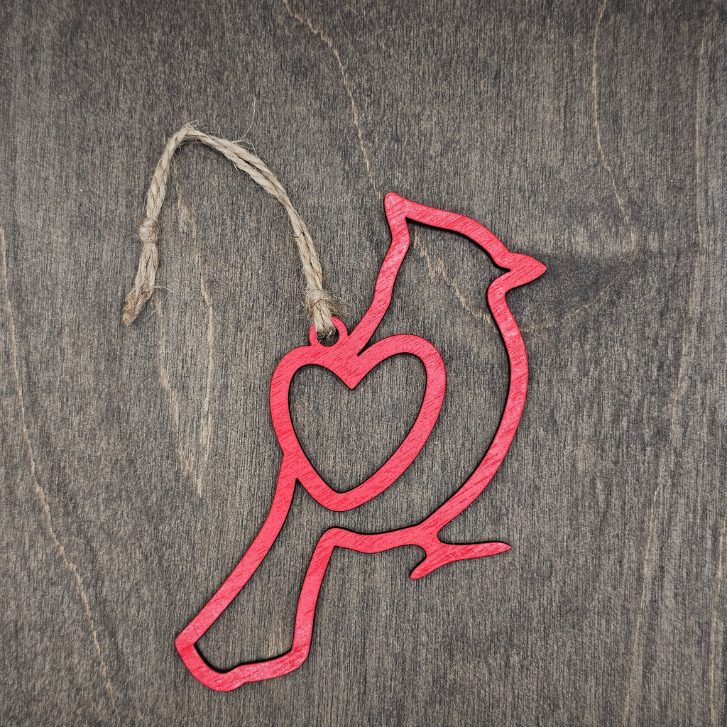 Laser cut red Cardinal wood ornament with open heart silhouette design, hung with natural jute cord