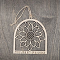 Laser cut wood sunflower ornament in an arched frame with detailed petal and seed head cutwork, "You Are My Sunshine" engraved at the base, hung with natural jute cord