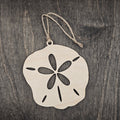 Laser cut wood sand dollar ornament with five-petal cutout and authentic slit detail, hung with natural jute cord