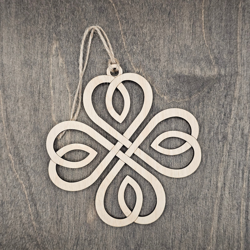 Laser cut Celtic knot wood ornament with intricate open interlace design, hung with natural jute cord