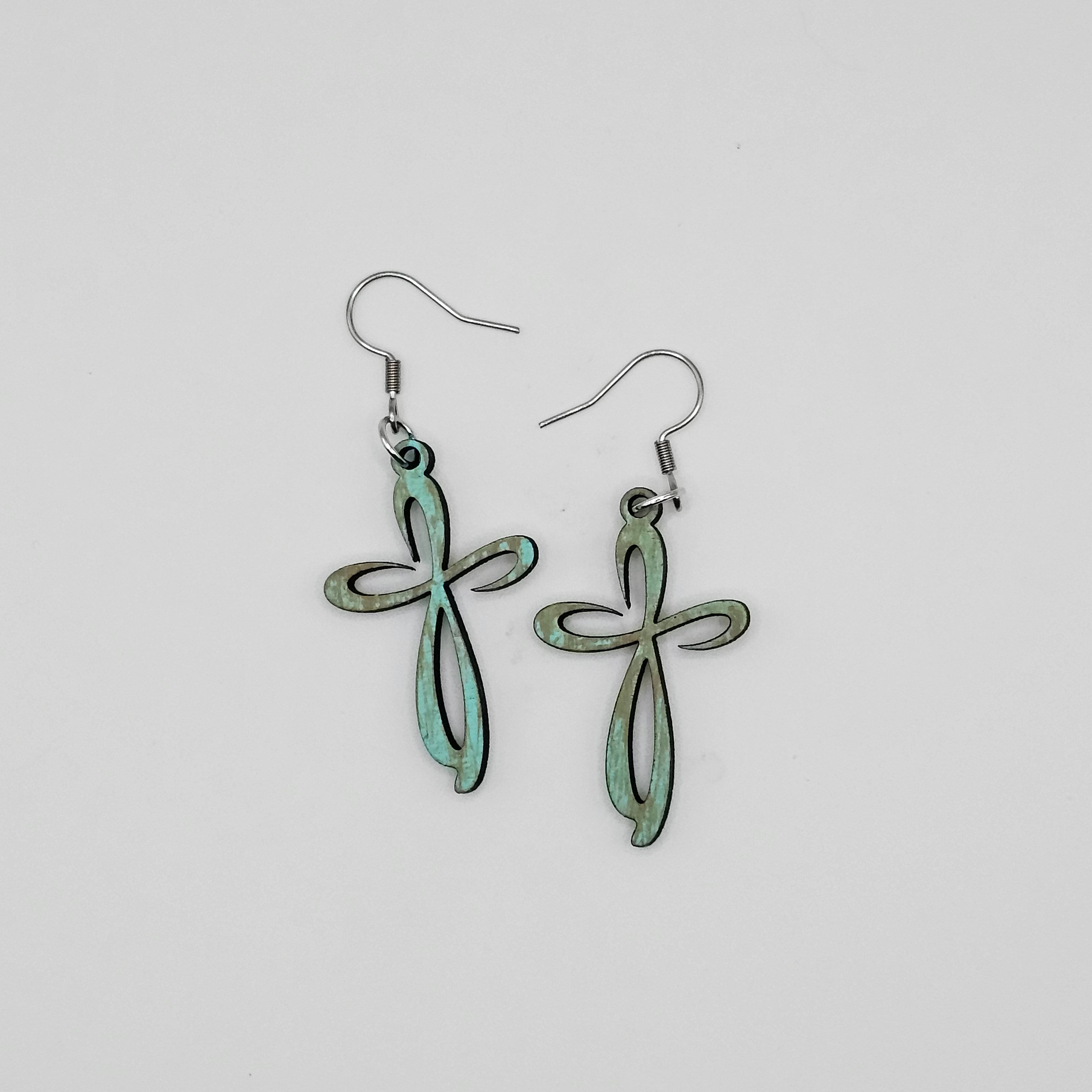 Pair of green leaf-shaped earrings on a light gray background