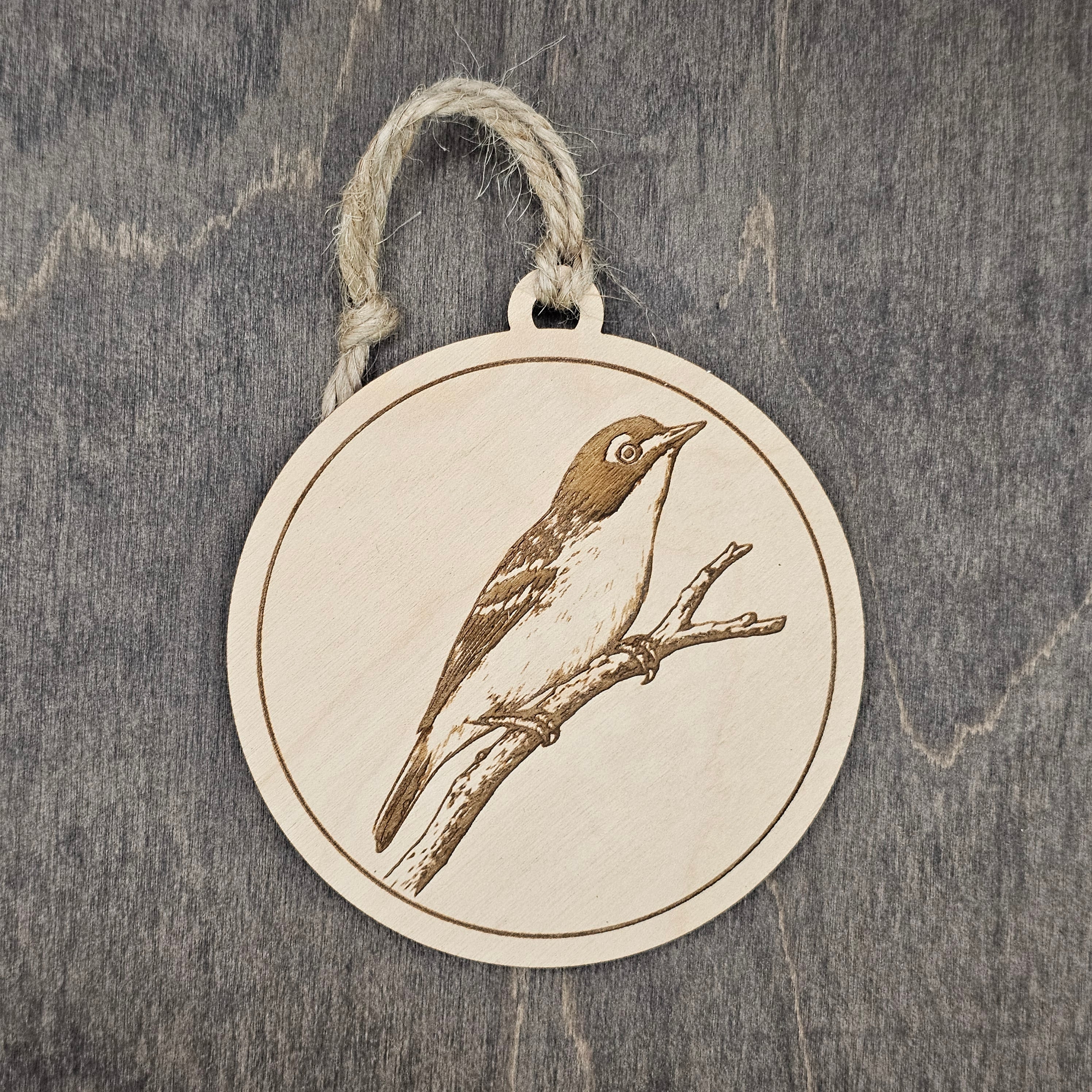 Laser engraved Black-capped Vireo wood ornament, featuring a detailed illustration of this federally protected songbird perched on a branch, hung with natural jute cord