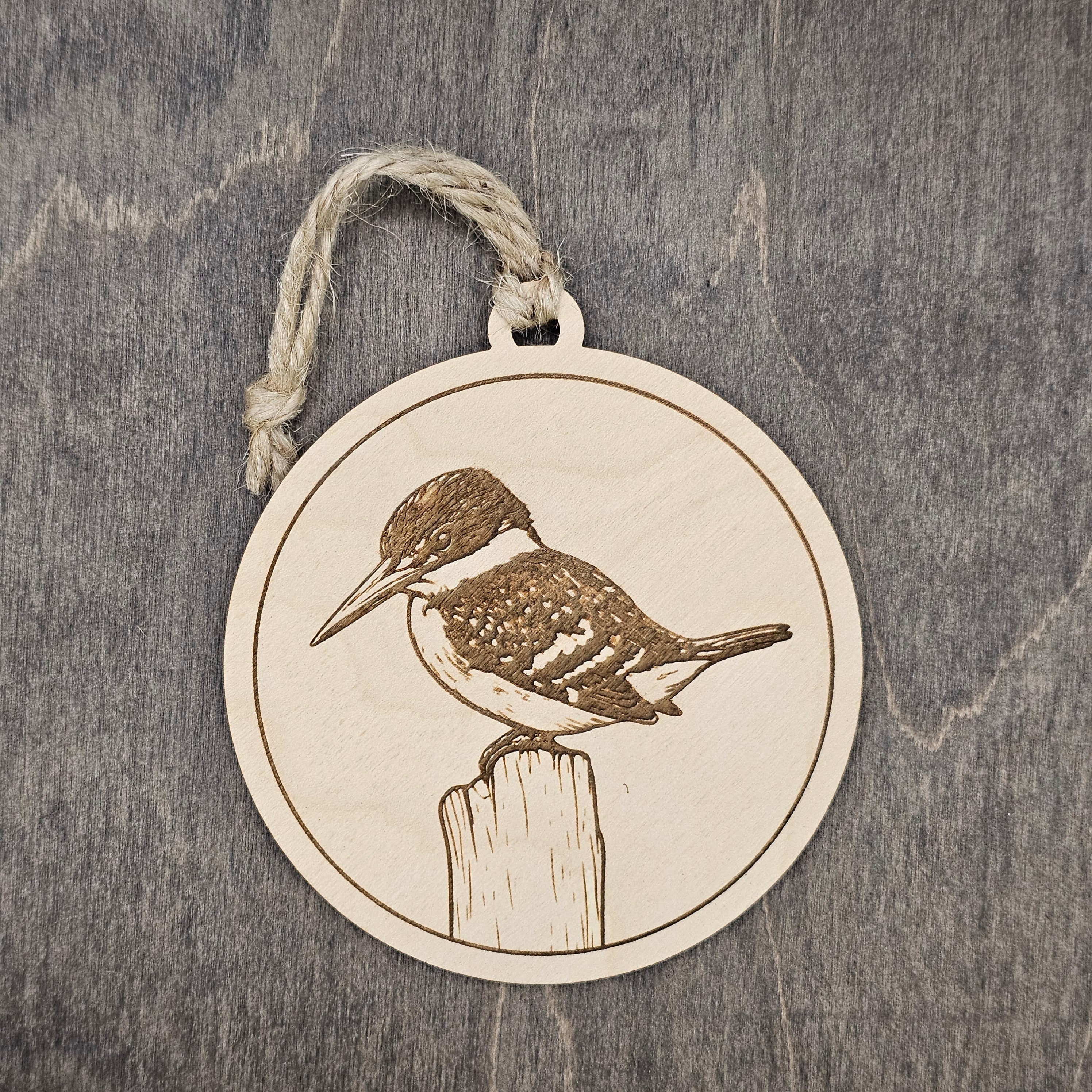 Laser engraved Green Kingfisher wood ornament, featuring a detailed bird illustration perched on a wooden post, hung with natural jute cord