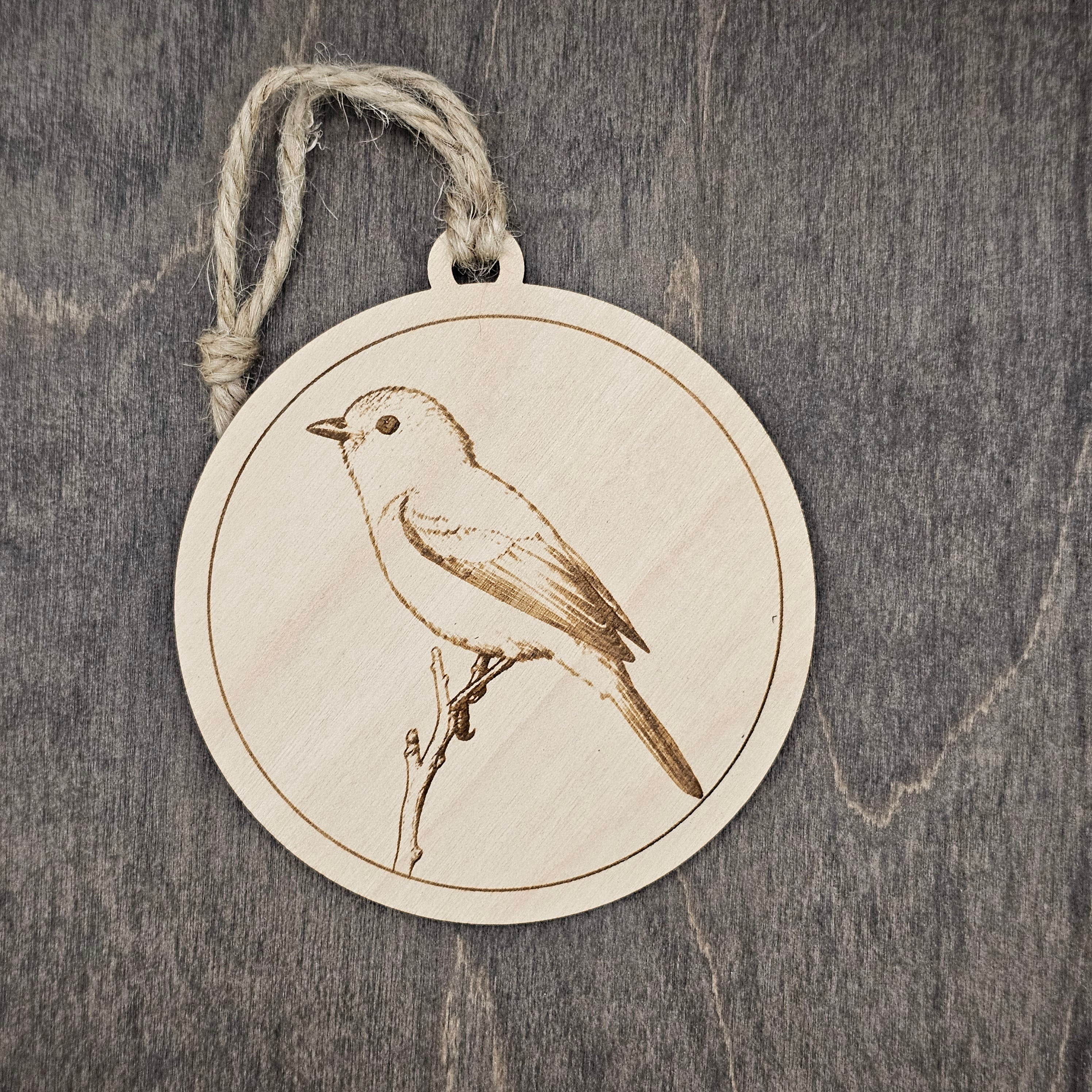 Laser engraved Gray Vireo wood ornament with detailed engraved illustration, perched on a bare branch, hung with natural jute cord
