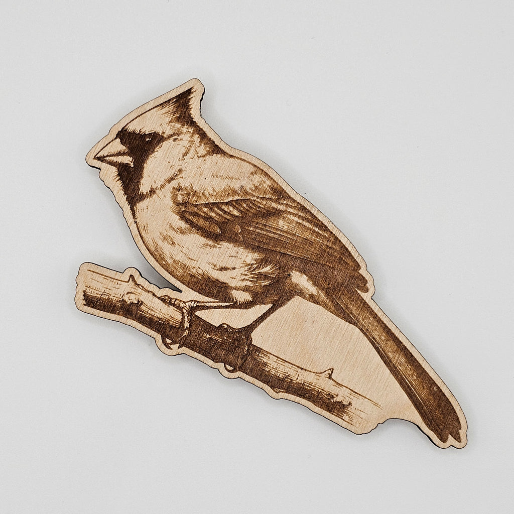 Laser-engraved wood magnet shaped like a cardinal perched on a branch with detailed feather engraving