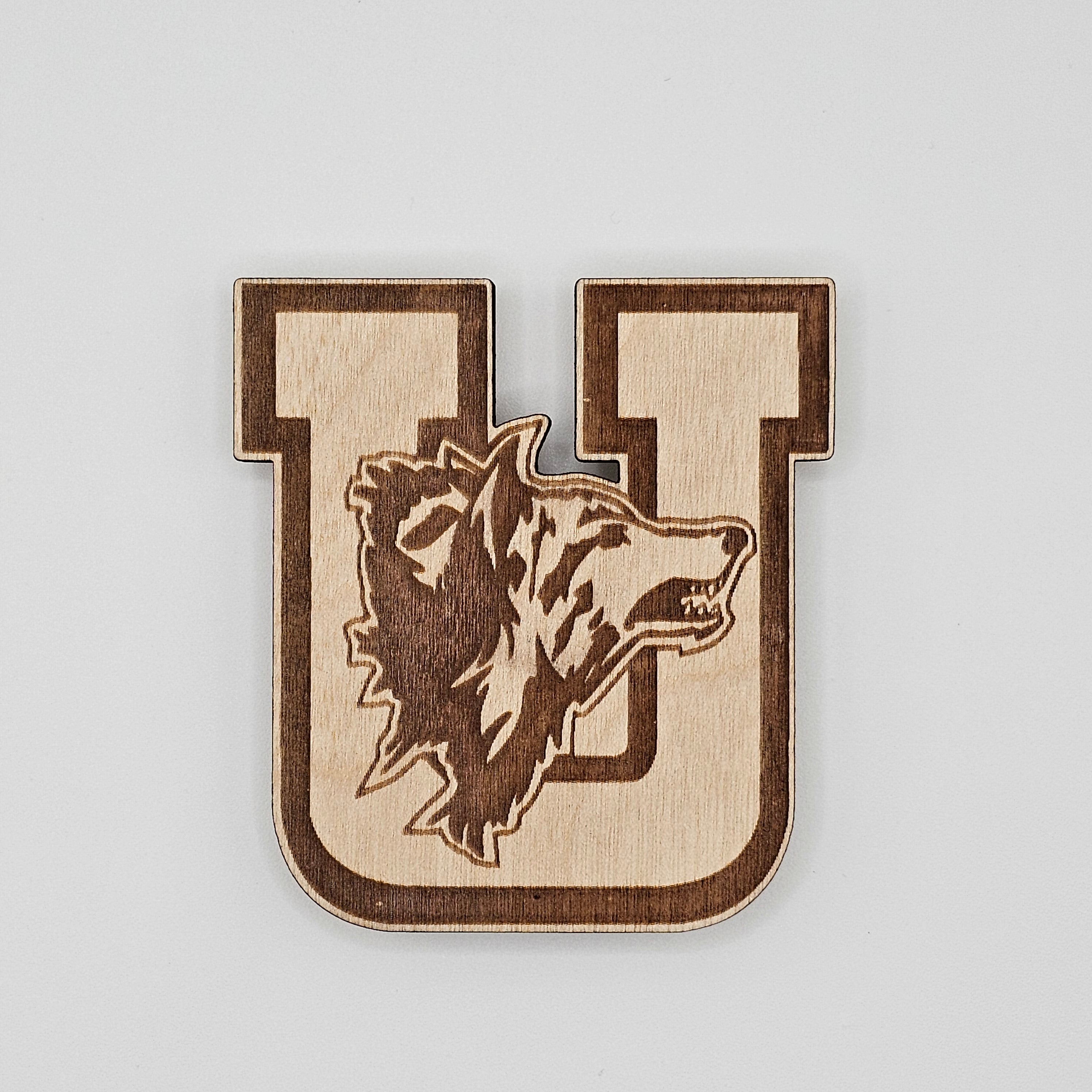 Laser-engraved wood magnet shaped like a varsity letter U with howling wolf mascot silhouette