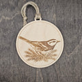 Laser engraved Golden-cheeked Warbler wood ornament, featuring a detailed illustration of this endangered Texas songbird nestled among juniper foliage, hung with natural jute cord