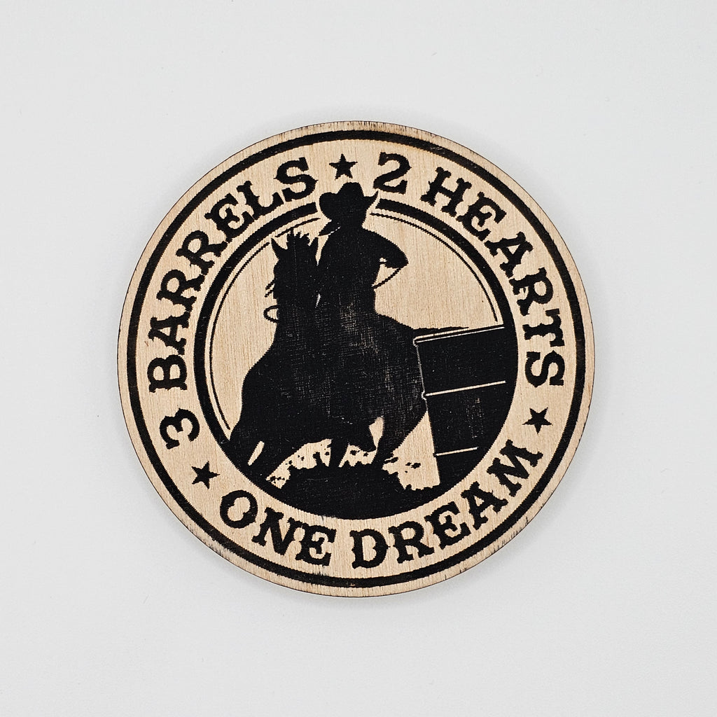 Round laser-engraved wood magnet with barrel racer and horse silhouette, reading 3 Barrels 2 Hearts One Dream, black on natural wood