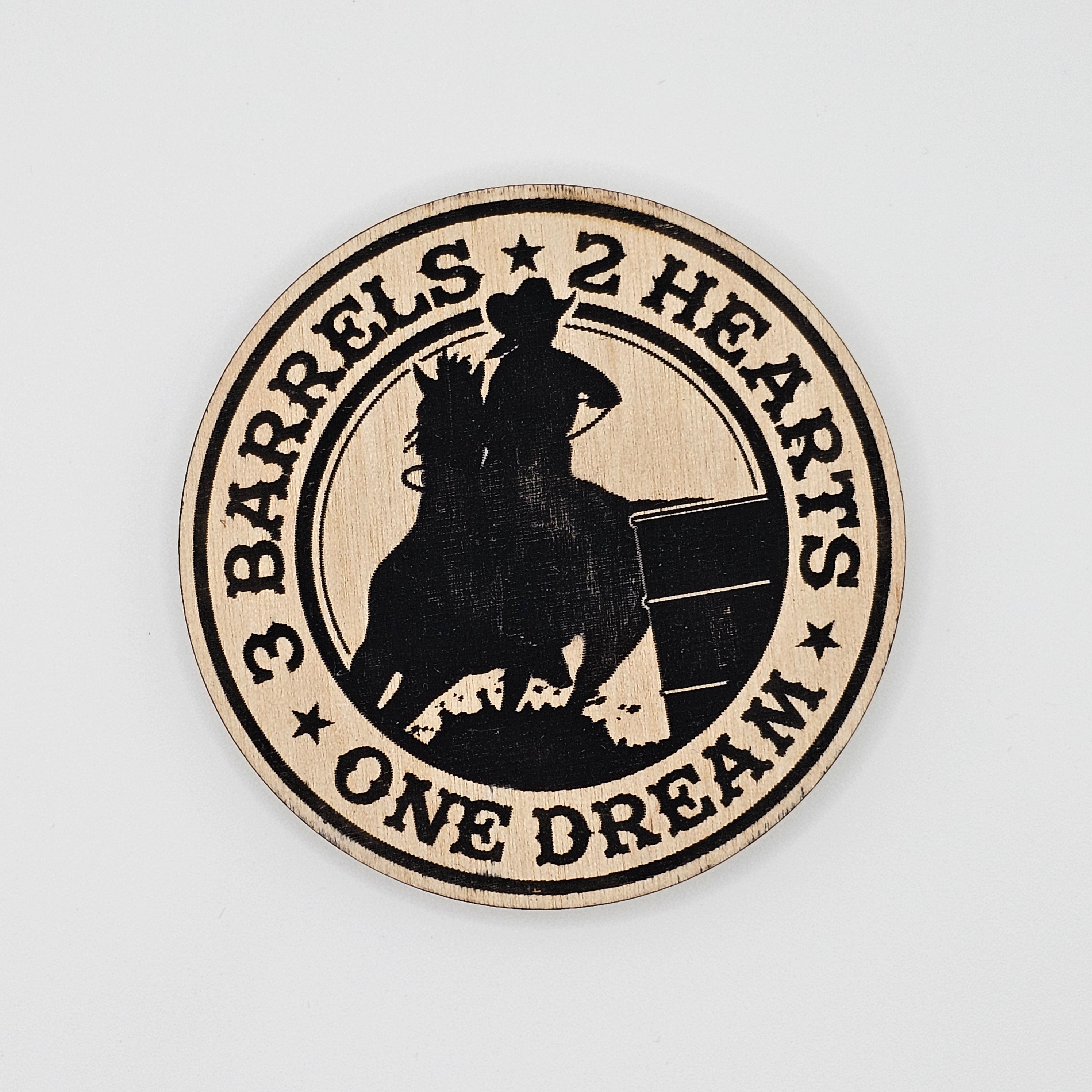 Round laser-engraved wood magnet with barrel racer and horse silhouette, reading 3 Barrels 2 Hearts One Dream, black on natural wood