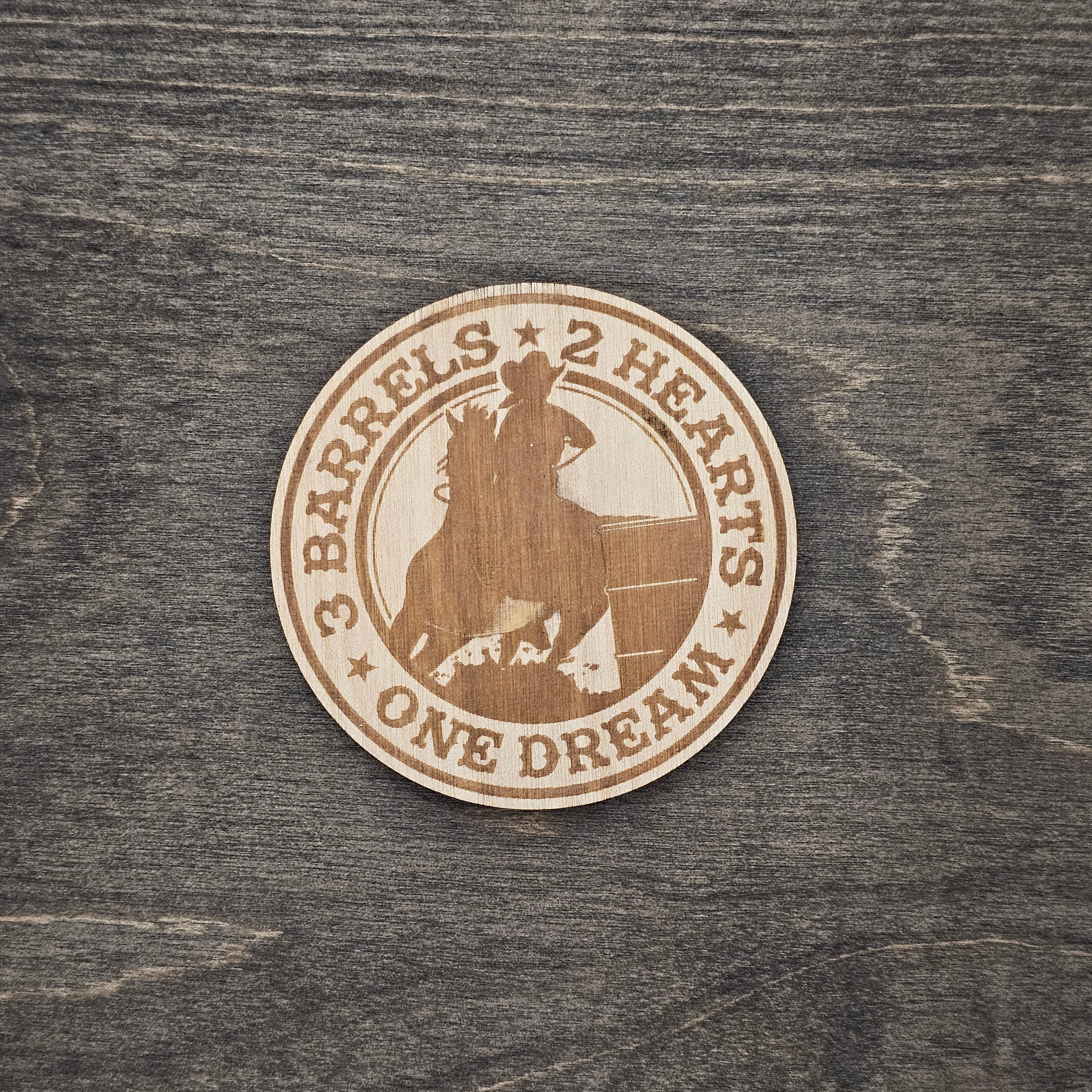 Round laser-engraved wood magnet with barrel racer and horse silhouette, reading 3 Barrels 2 Hearts One Dream